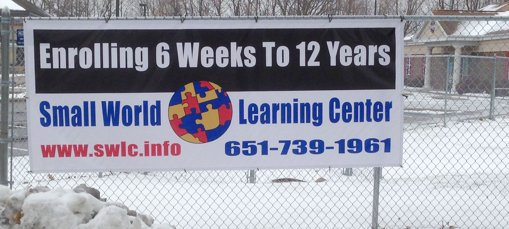 Small World banner on fence, Minnesota signs